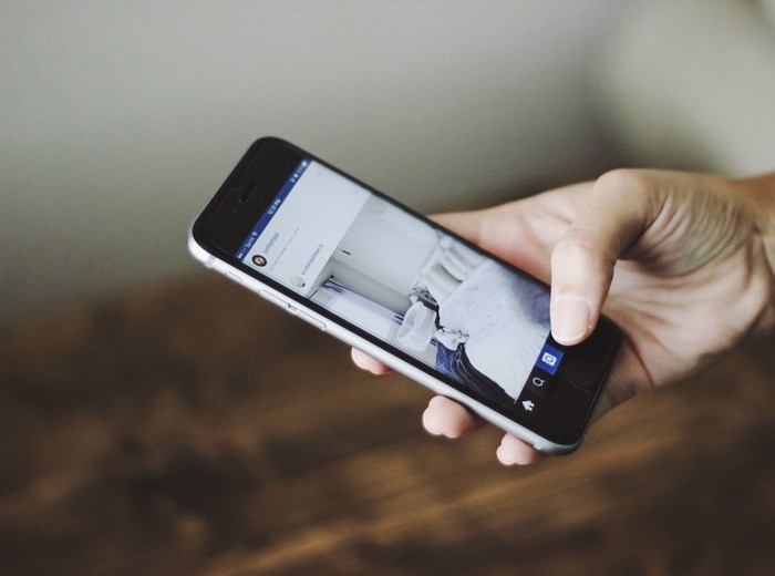 Person holding an iPhone showing Instagram