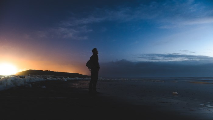 Silhouette of a person on a beach at dusk