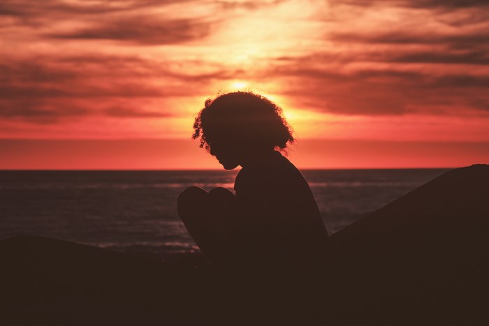 Silhouette of a girl against a sunset sky