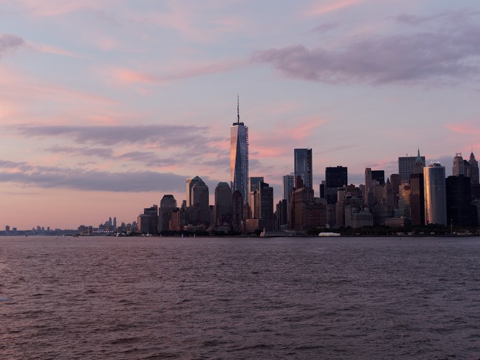 New York City skyline at sunset over the ocean