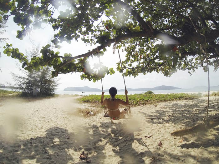 Woman on a swing at the beach