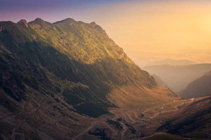 Mountain road at sunrise with haze