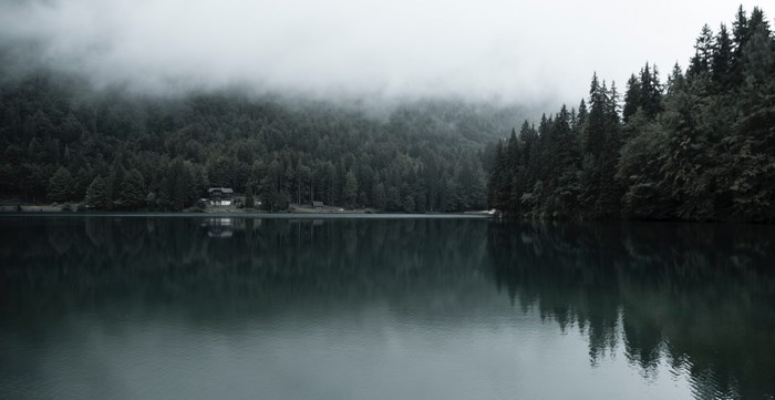 Misty lake with forest and house in Italy