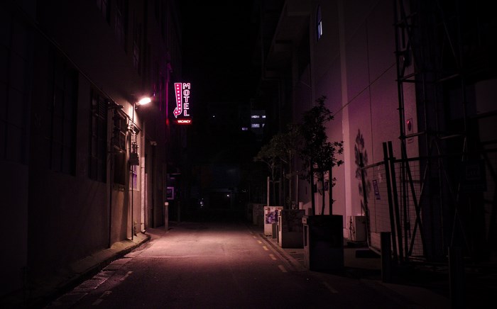 Motel neon sign in a dark alley at night