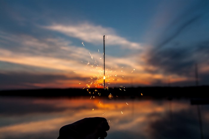Sparkler against a sunset over a lake