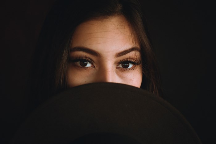 Woman's eyes peeking over a hat
