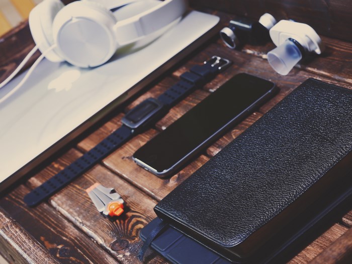 Apple MacBook with headphones, watch, and phone