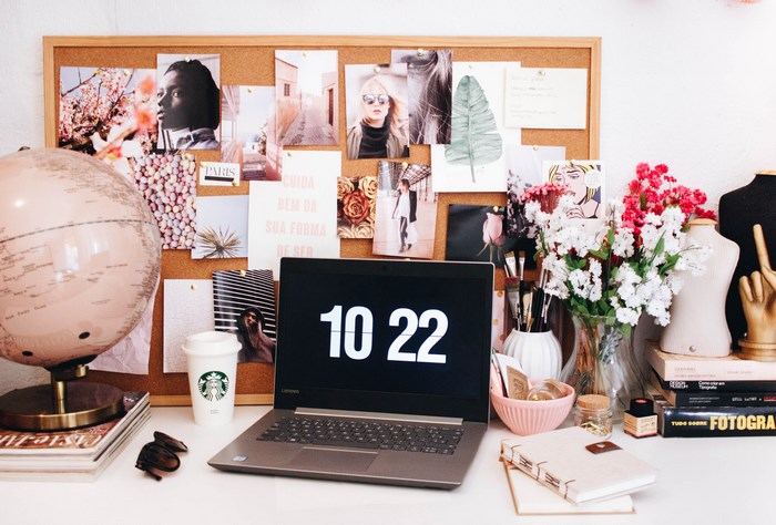 Desk with laptop, globe, and mood board