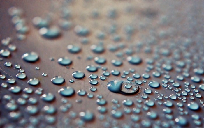 Water drops on a textured surface with bokeh