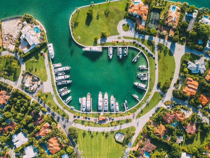 Aerial view of a marina with yachts and luxury homes