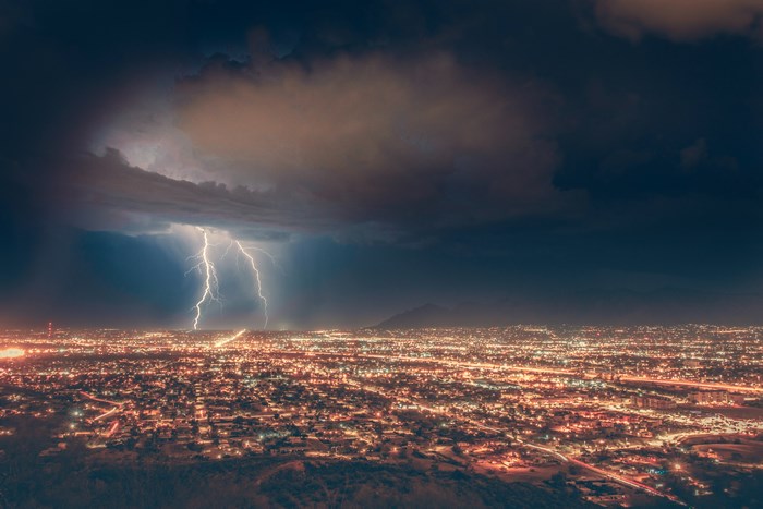 Lightning strikes over a city at night
