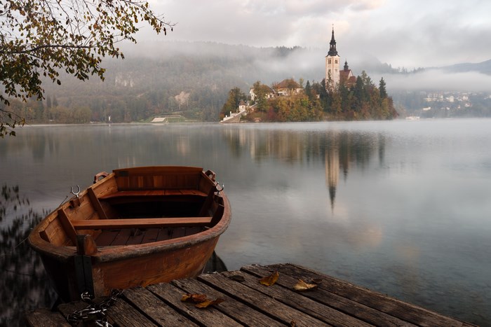 Wooden Boat at Sunrise on Lake Bled with Island Church
