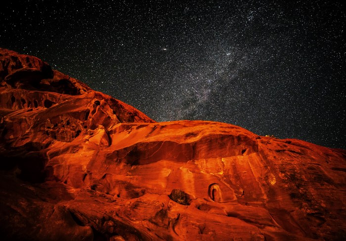 Red rock formations under a starry night sky