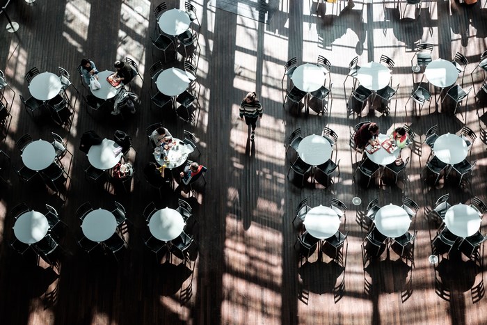 People dining at tables in a sunlit cafe