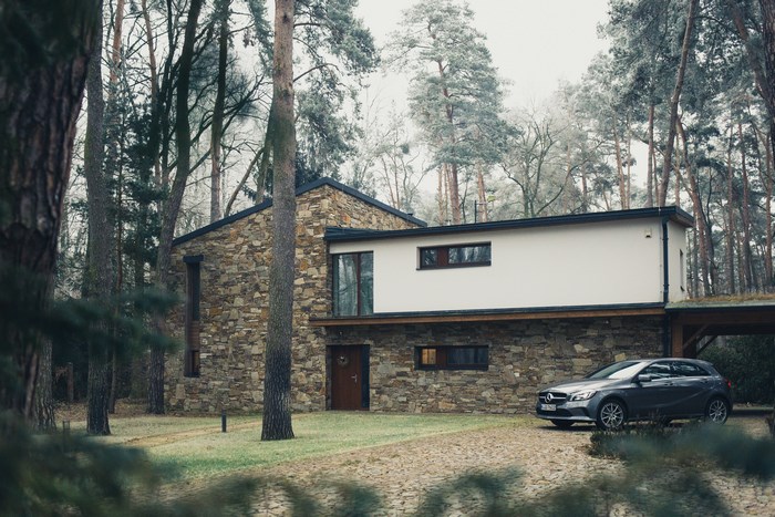Modern stone house with Mercedes car in a forest