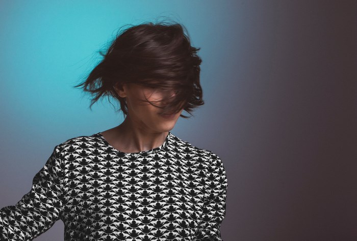 Woman with dark hair in a patterned shirt