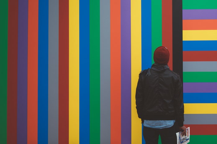 Person in beanie looking at colorful stripes art