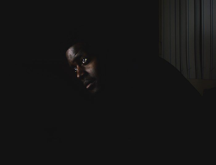 Man's face in shadow, looking to the side