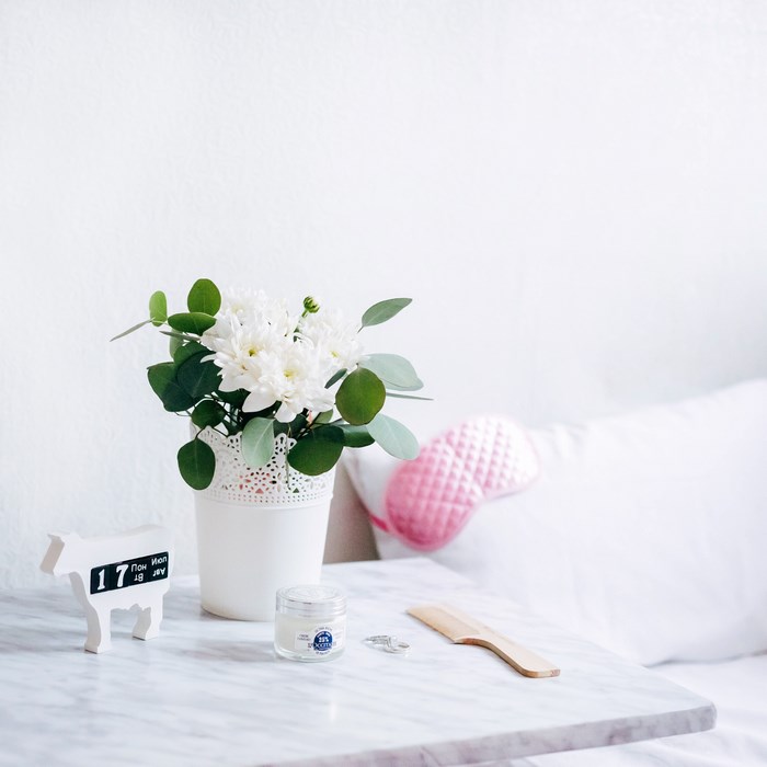 White flowers and a cow-shaped calendar on a marble table