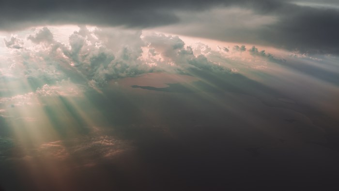 Sunlight rays through storm clouds over water