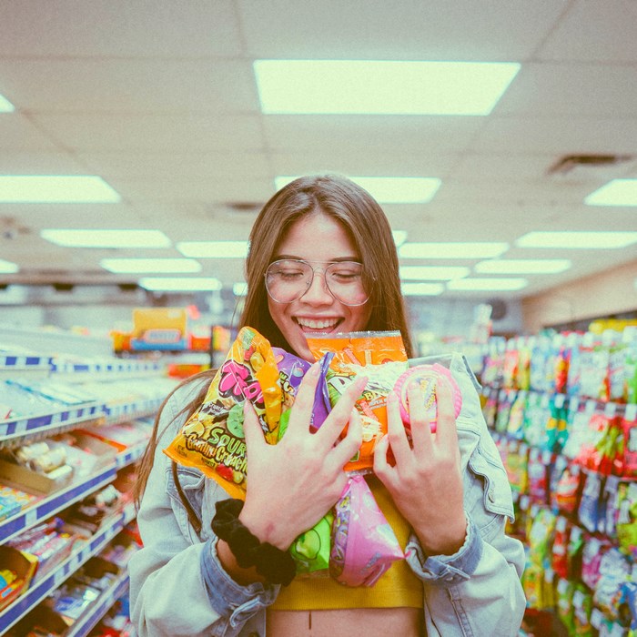 Woman smiling and holding candy in a store