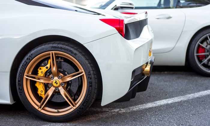 White Ferrari sports car with bronze wheels and yellow calipers