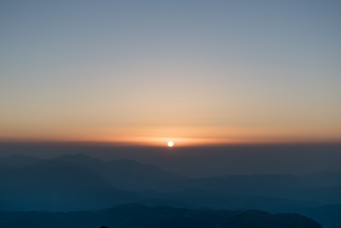 Sunset over layered mountains in Greece