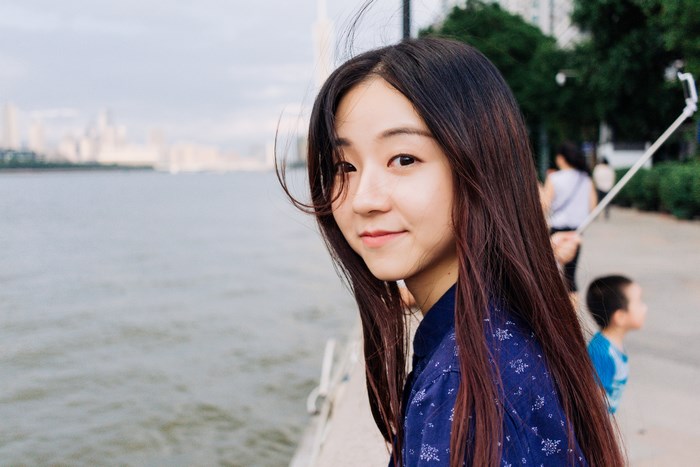Young woman with long dark hair by a river