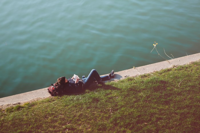 Person reading by the water