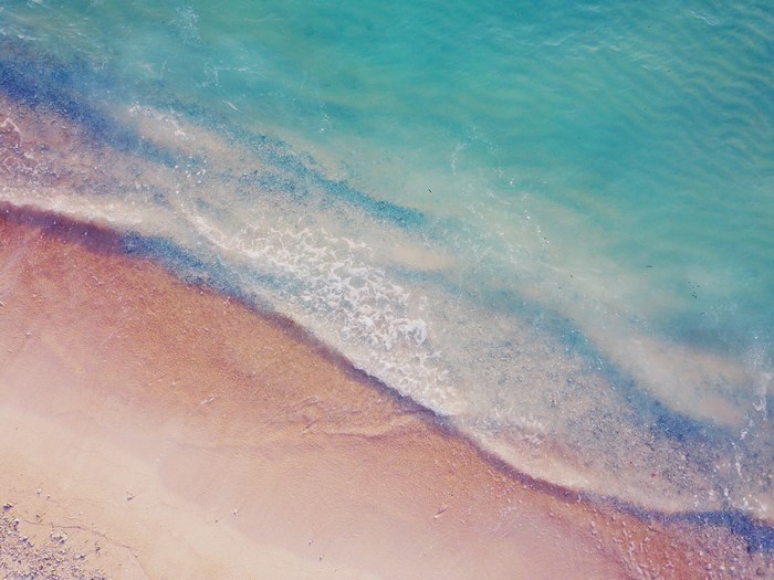 Aerial view of a sandy beach and turquoise ocean waves