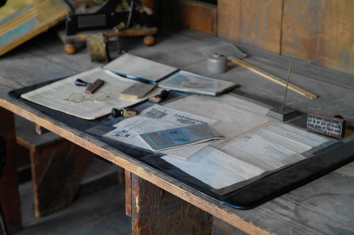 Desk with papers, glasses, and stamps
