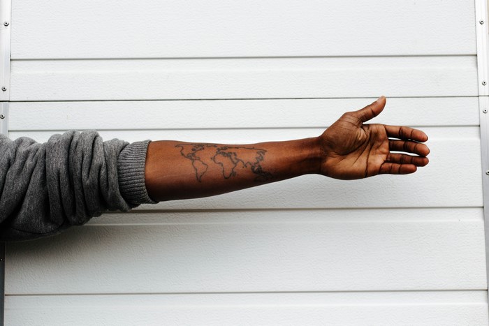 Person with world map tattoo on arm