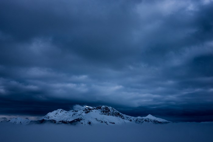 Snowy Grigna Settentrionale mountain under dark clouds