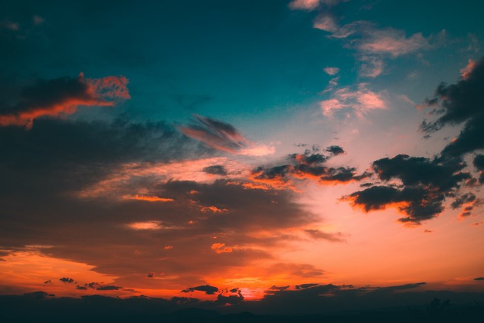 Sunset sky with orange and teal clouds