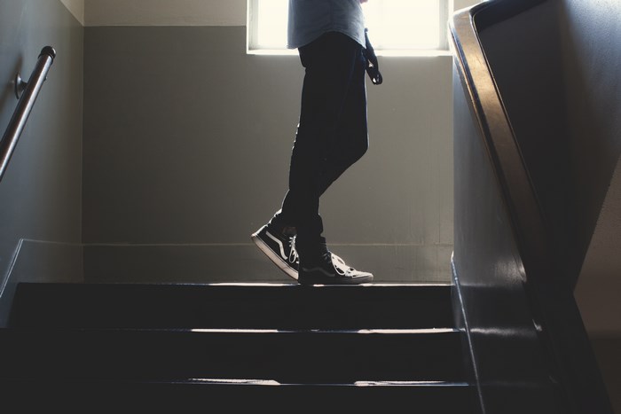 Person walking down stairs in sunlight