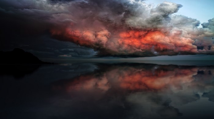 Dramatic Red Cloudscape Over Calm Coastal Water