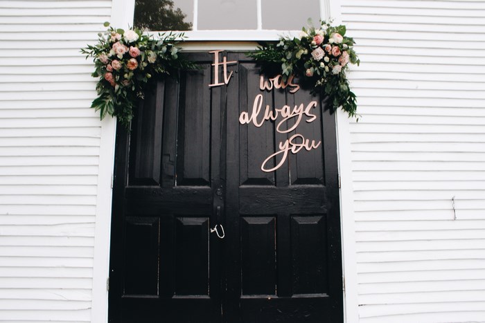 Wedding decor with flowers and text on black doors