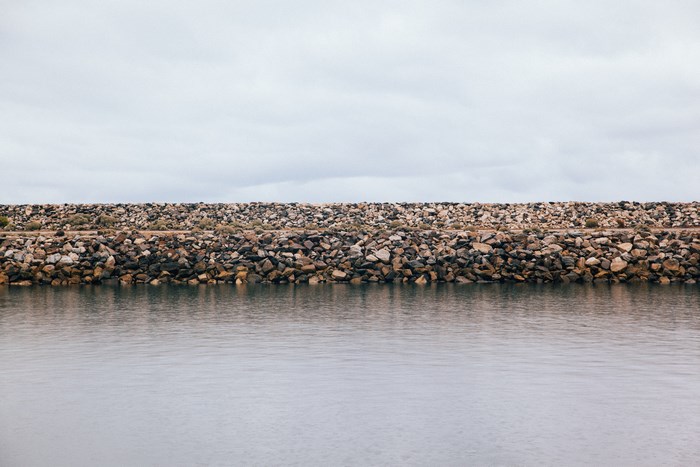 Stone levy with water and cloudy sky