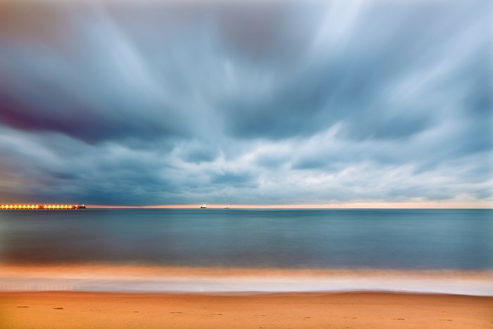 Long exposure of a beach with stormy clouds and ocean
