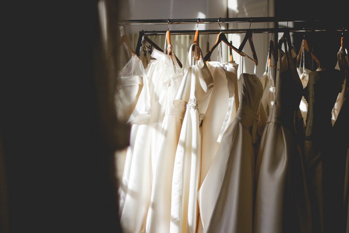 Wedding dresses hanging on a rack in a boutique
