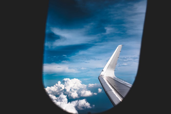 Airplane wing seen through a window at high altitude