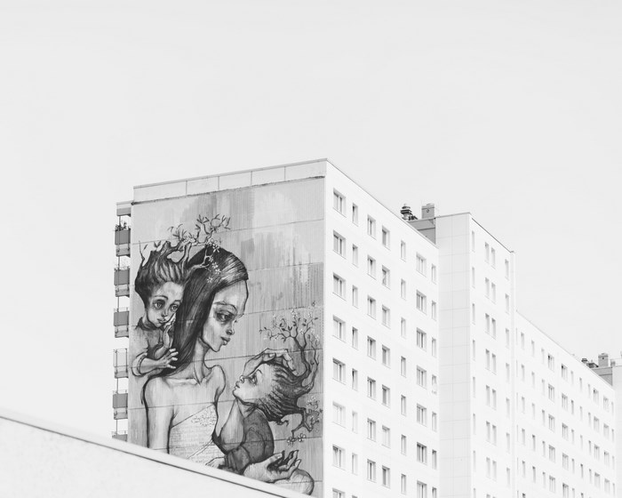 Graffiti art of a mother and children on a building facade