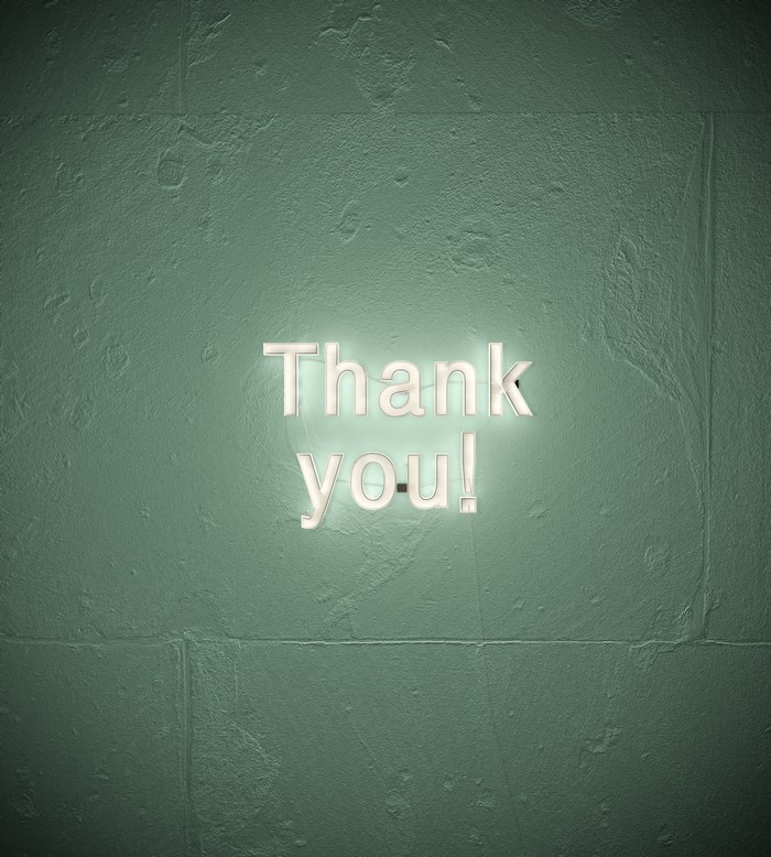 Thank you neon sign on a textured green wall