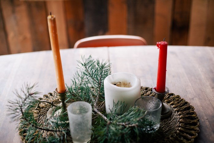 Christmas candle arrangement with pine branches on a wooden table