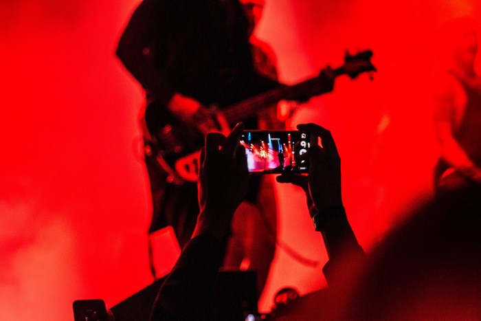 Concert performance with a guitarist and audience filming
