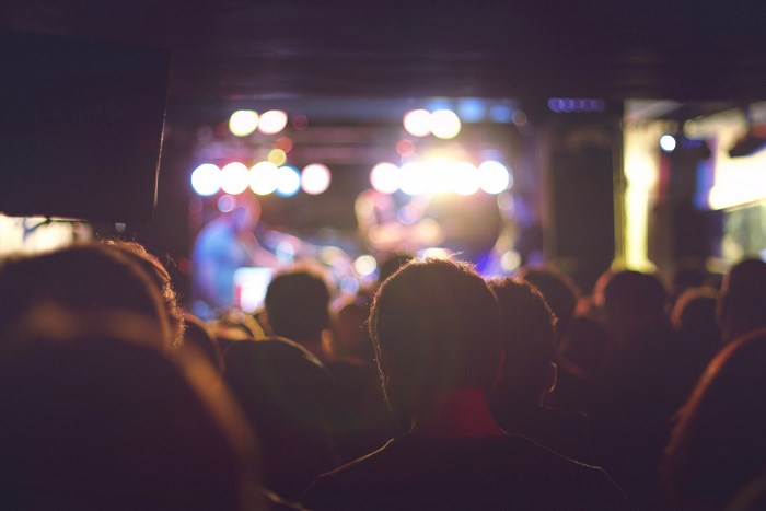 Concert crowd watching a performance with bright stage lights