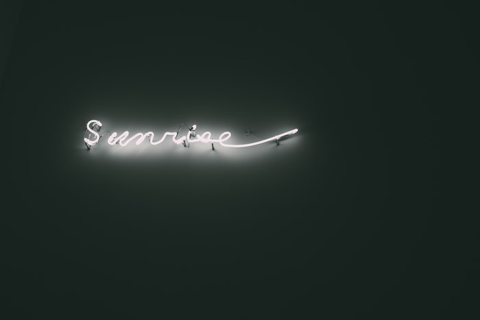 Glowing Neon 'Sunrise' Sign on Dark Background