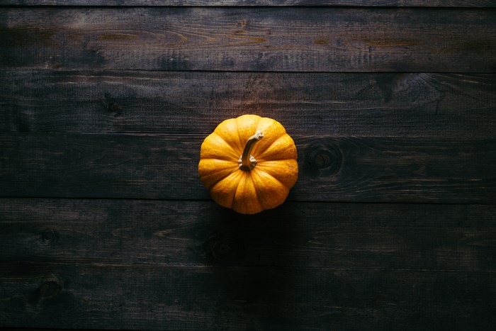 Orange pumpkin on a dark wooden table