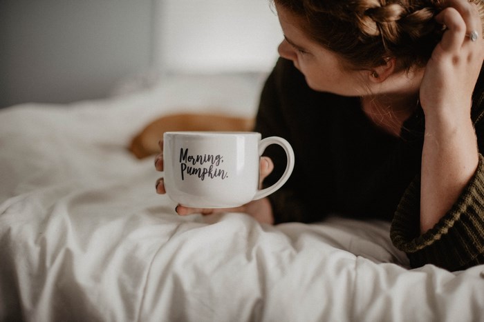 Woman holding a mug that says "Morning, Pumpkin."