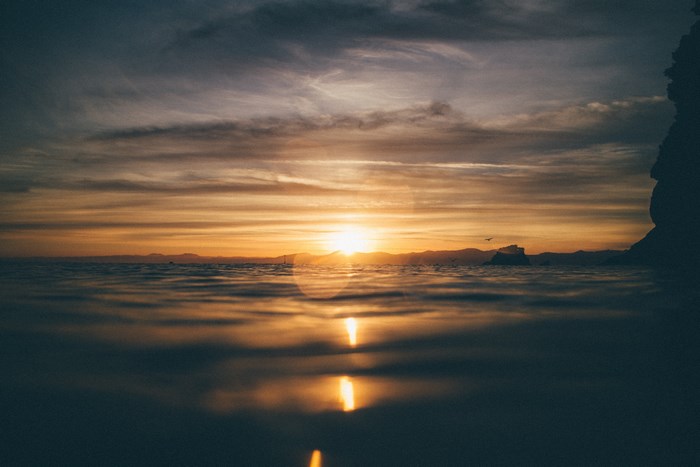 Sunset over the ocean with mountains